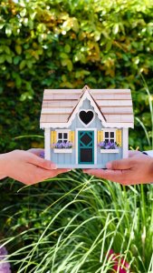 people holding a miniature wooden house